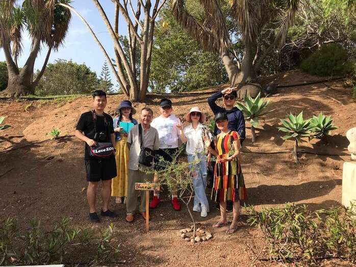 Grupo de chinos posa junto al olivo plantado en el parque urbano de San Juan en recuerdo de Sanmao (Foto TA)